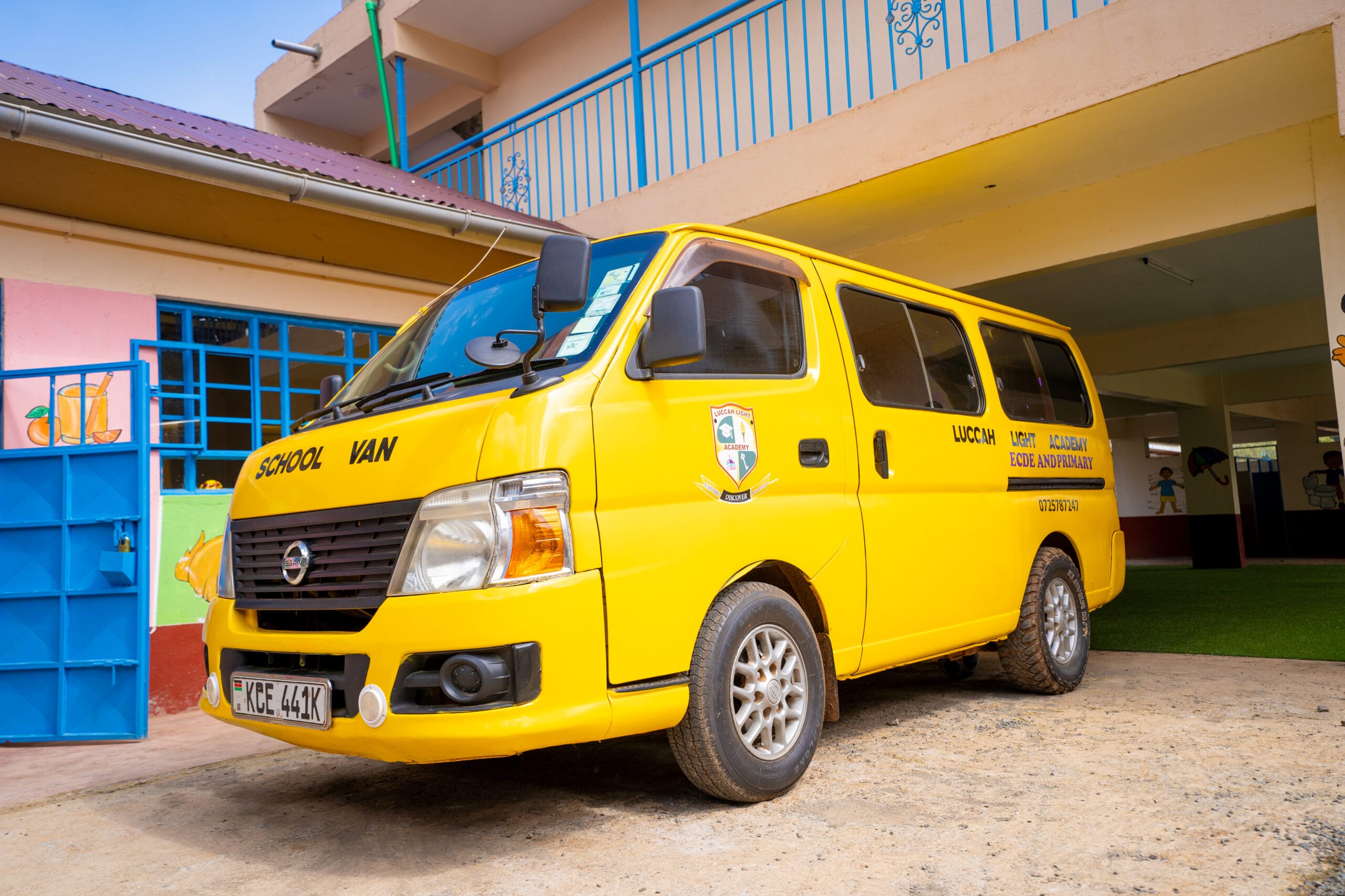 Yellow Luccah Light Academy school van parked outside the school building.